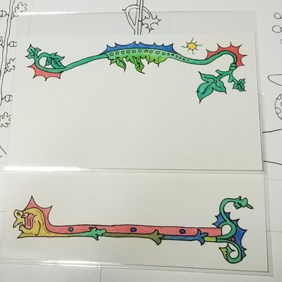 a photo of two 3x5 cards with borders adapted from medieval manuscripts. The upper card has a 
		leafy border. The lower card has a strange beast at the left end. The beast's tail forms the border and splits into two at the right end.
