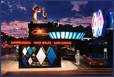 image of Superdawg, a drive-in, at sunset, and two large fiberglass hot dog characters on the roof
